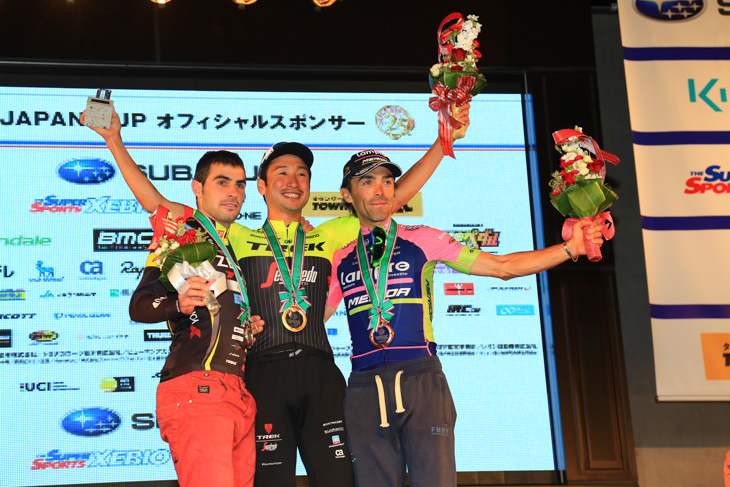 クリテリウム表彰式。優勝別府史之、2位ジョン・アベラストゥリ（チームUKYO）、3位マヌエーレ・モーリ（ランプレ・メリダ）花束はヒューマンアカデミー株式会社提供